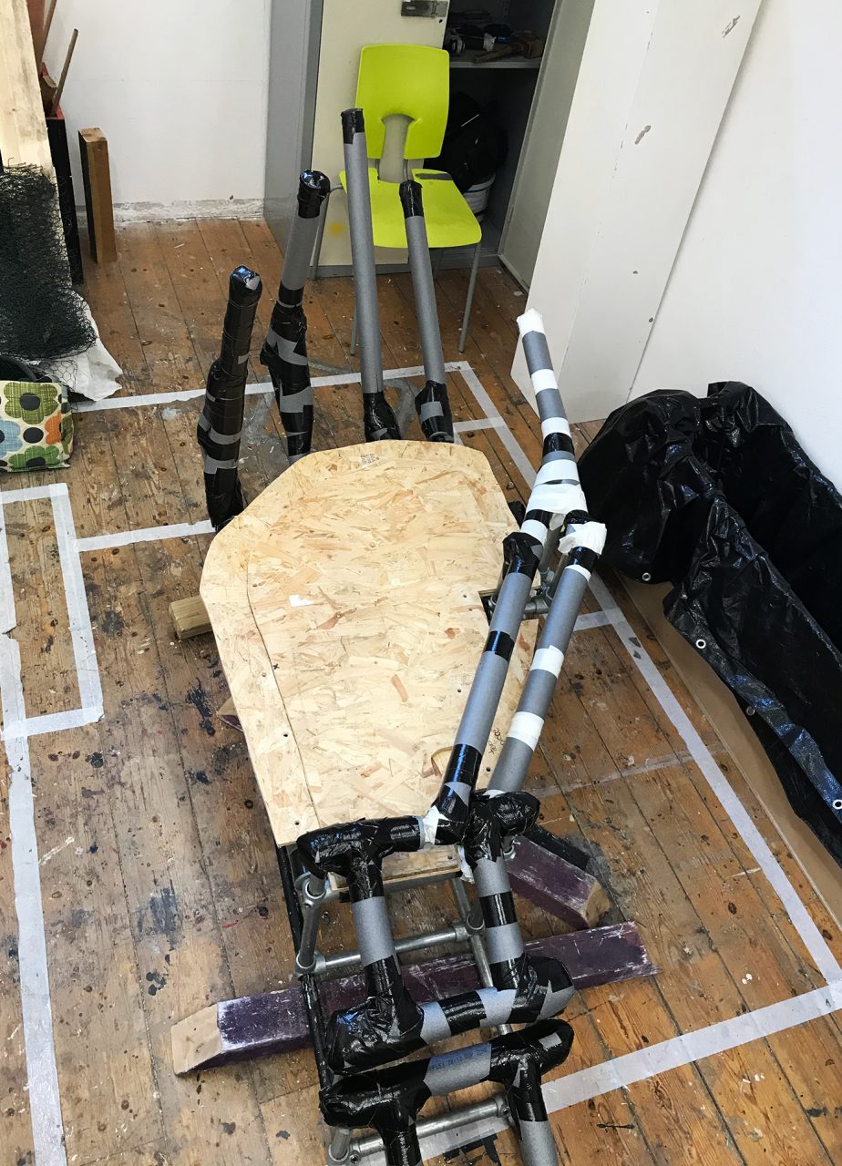 Photograph of steel scaffolding as the skeleton of the hand- with wooden base. Photo taken in the workshop.