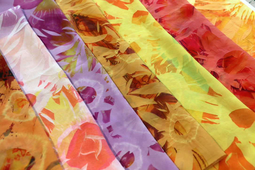 several pieces of printed fabric laid out in colour order